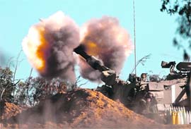 An Israeli mobile artillery unit fires a shell towards Gaza from its position outside the central Gaza Strip on Tuesday. 