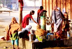 Women throng a handpump at new grain market in Abohar