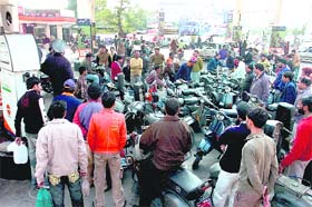 People queue up outside a filling station in Jammu