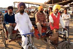 Munshi Singh (left) and Kaur Singh pulling rickshaws with one arm in Bathinda