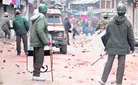Policemen hold shields to save themselves from stone-pelting protesters holding a demonstration in Srinagar on Friday in protest against the Israeli attacks on Gaza