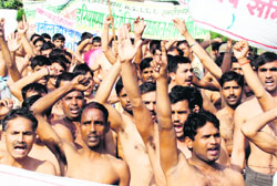 Former personnel of the Haryana Industrial Security Force stage a demonstration in front of the mini secretariat in Karnal