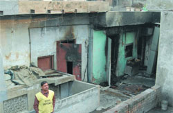 A civil defence guard stands outside the gutted office in New Delhi