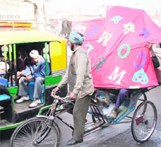 A boy looks at a huge kite being carried on a rickshaw in Ludhiana on Tuesday.