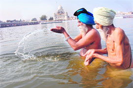 Devotees take a dip in the sarovar of Gurdwara Tuti Gandi Sahib on the occasion of Maghi in Muktsar on Tuesday.