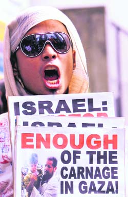 A peace activist shouts near the Israeli embassy in metro Manila on Tuesday, during a protest against Israels attacks on Gaza.
