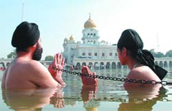HOLY DIP: Devotees pray at Bangla Sahib Gurdwara on the occasion of Makar Sankranti in New Delhi on Wednesday. 