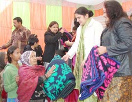 Gurgaon deputy commissioner Deepti Umashankar distributes blankets to the poor on Wednesday. 