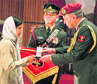 Lt-Gen P.C. Bhardwaj, GoC-in-C, Northern Command, gives away the gallantry seva medal to Sumit Dogras widow in Akhnoor on Thursday