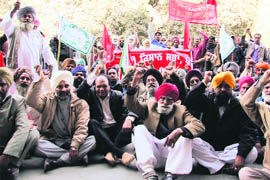 Members of the Bharti Kisan Union hold a dharna outside the Deputy Commissioner’s office demanding cut in prices of petrol, diesel, LPG and other taxes in Ludhiana on Thursday.
