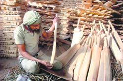 A worker makes a cricket bat in the Gangyal industrial area in Jammu.