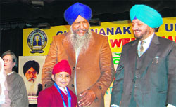 Gulzar Singh Ranike, Animal Husbandry and Sports Minister, Punjab, gives away a special prize to his grandson during the 14th National Youth Festival in Amritsar