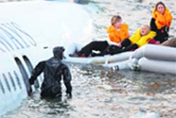 passengers are ferried in a boat to safety. 