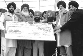 Chief Minister Parkash Singh Badal hands over a cheque for the Municipal Council, Mohali, at a sangat darshan programme