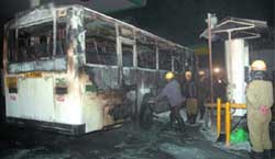 Firemen try to douse the fire in a chartered CNG bus at IP gas station in New Delhi 