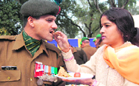 Lance Naik Vikram Singhs wife offers sweets after he was felicitated with Sena Medal during the Army Investiture ceremony at Amritsar Cantt on Saturday.