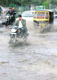 Traffic wades through a waterlogged road in Jammu after a downpour