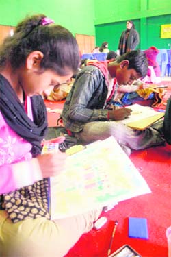 Students participating in a painting competition at the indoor stadium at Shimla on Monday.