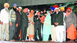 Chaudhary Swarna Ram, Swami Shankara Nand and others hand over a child to an issueless couple at the annual day of the SGB International Foundation in Talwandi Khurd.