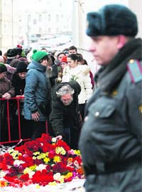 People lay flowers at the site where lawyer Stanislav Markelov and reporter Anastasia Baburova were shot in Moscow