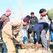 Railway staff busy mending the track at Rawalpora (Budgam) on Wednesday. 