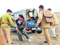Police officials tackle a BJP leader protesting against the anti-encroachment drive in Haridwar on Thursday.