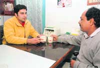 Aniket (left) with a client at his office 