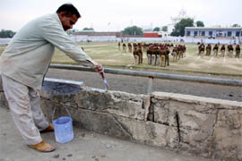 A painter gives a coat of paint to the cracked walls and railings at the sport stadium in Bathinda on Friday.
