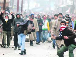 Kashmiri agitators throw stones at security personnel during a protest in Srinagar