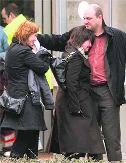Parents react as they leave a building where families received assistance near the scene of a knife attack at a creche in Dendermonde area of Belgium on Friday. An assailant killed two children and an adult. Ambulance services said at least 10 others had been injured.