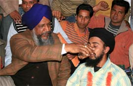 Gulzar Singh Ranike, minister for animal husbandry, offering juice to the pharmacist who was on hunger strike in Bathinda on Sunday. 