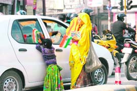 A woman, along with her daughter, sells national flags at Darshan Lal Chowk in Dehradun on the eve of Republic Day.