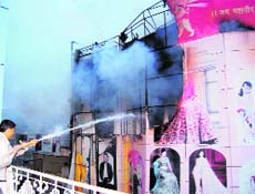 A firefighter battles flames that engulfed a showroom in Sirsa on Sunday.