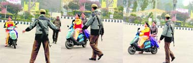 A policeman tries to stop girls on a scooter for violating traffic rules at Bikram Chowk in Jammu, but the latter turn their vehicle and speed away