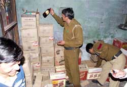 Police officers investigate an illegal stock of wine at Hira Nagar in Gurgaon