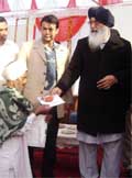 CM Parkash Singh Badal hands over keys of a house to a beneficiary.