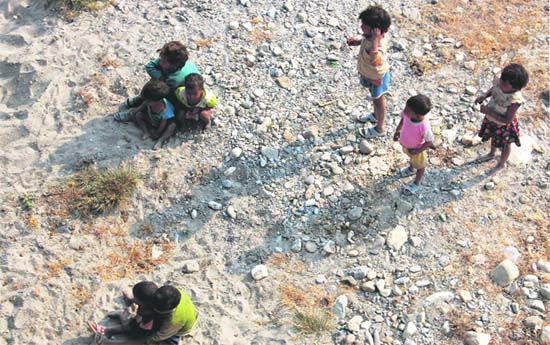 Slum children stray onto a riverbed on the outskirts of Dehradun. 