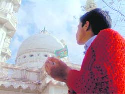 A child offers prayers at the Sain Miran shrine near the LoC in Poonch. A Tribune photograph
