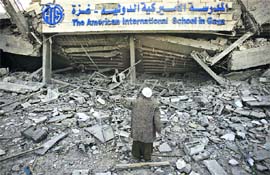 A Palestinian stands next to the debris of the destroyed American International School in Beit Lahiya, north of Gaza Strip, on Thursday.