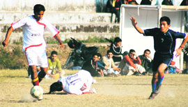 A Doon Valley player dodges his opponent from Potala XI in Dehradun on Saturday.