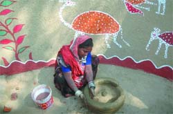 A woman from Madhya Pradesh makes a clay pot during a media preview of the 23rd Surajkund Crafts Fair at Surajkund in Haryana