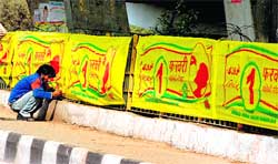 A labourer fixes a banner on the polio eradication drive at Dogra Chowk in 