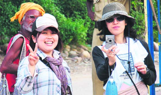 Two Japanese tourists click photographs in Haridwar on Sunday.