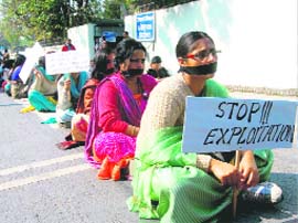 Protesting lecturers with placards against the government in Dehradun on Monday.