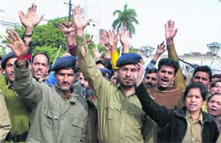 Home Guard jawans hold a protest outside the Divisional Commissioners office in Jammu on Monday.