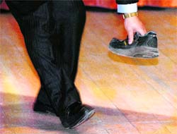 A security guard picks up the shoe thrown towards Chinese Premier Wen Jiabao at the University of Cambridge in England on Monday.