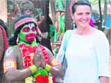 A tourist poses with a man dressed up as Lord Hanuman at the Surajkund Crafts Mela in Faridabad