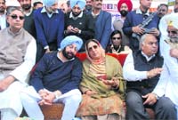 Former CM Amarinder Singh is all ears as Rajinder Kaur Bhattal shares a light moment with him at a rally in Nurmahal on Tuesday.