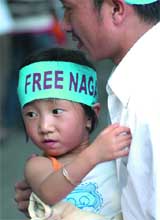 A man participates with his child in a protest called by the Delhi unit of the Naga Students Union to expedite political negotiations in Nagaland