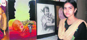 Chetna with her paintings at an exhibition in Fatehabad.